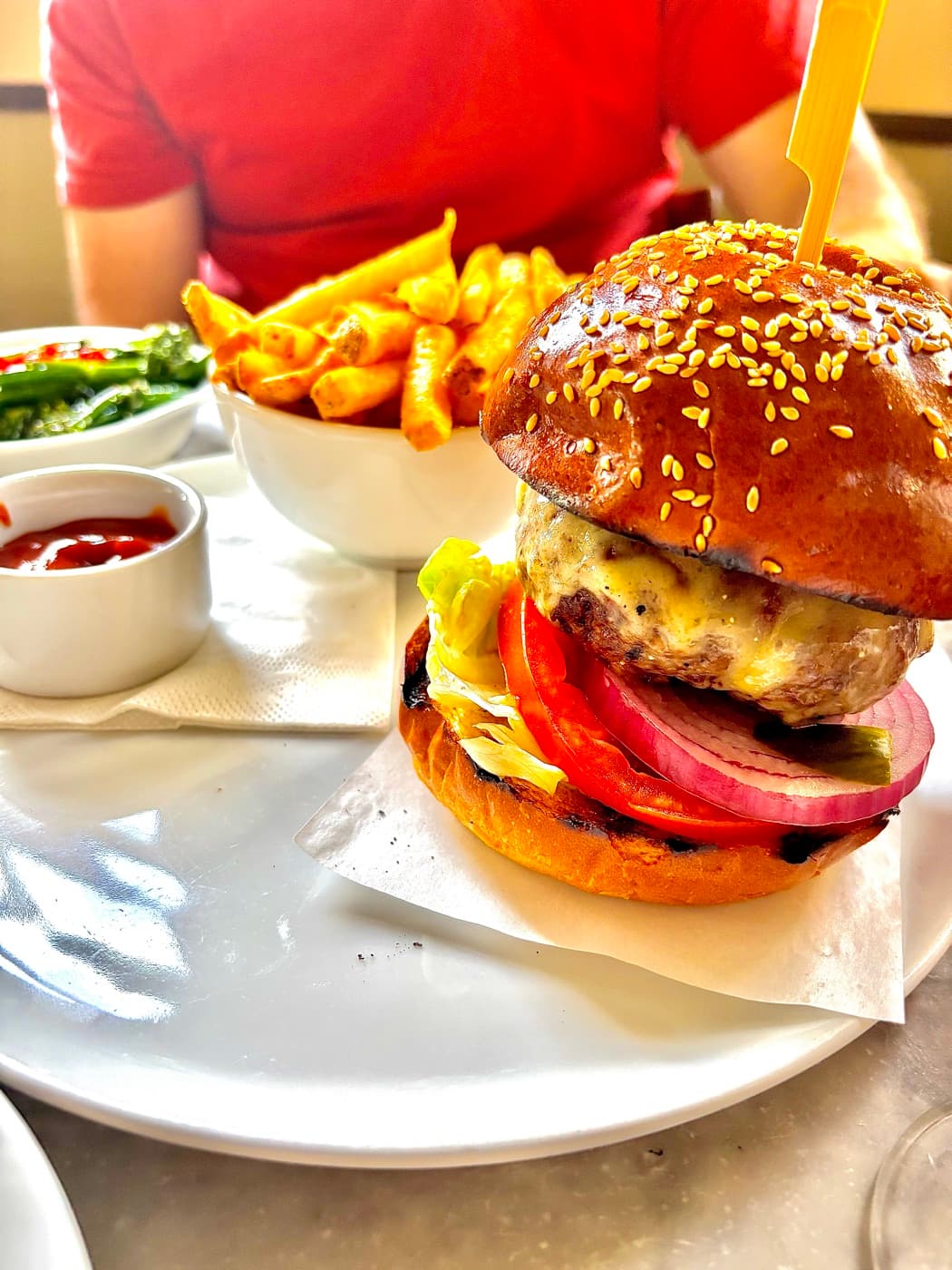 7oz burger with sesame brioche bun and skinny fries at Branca