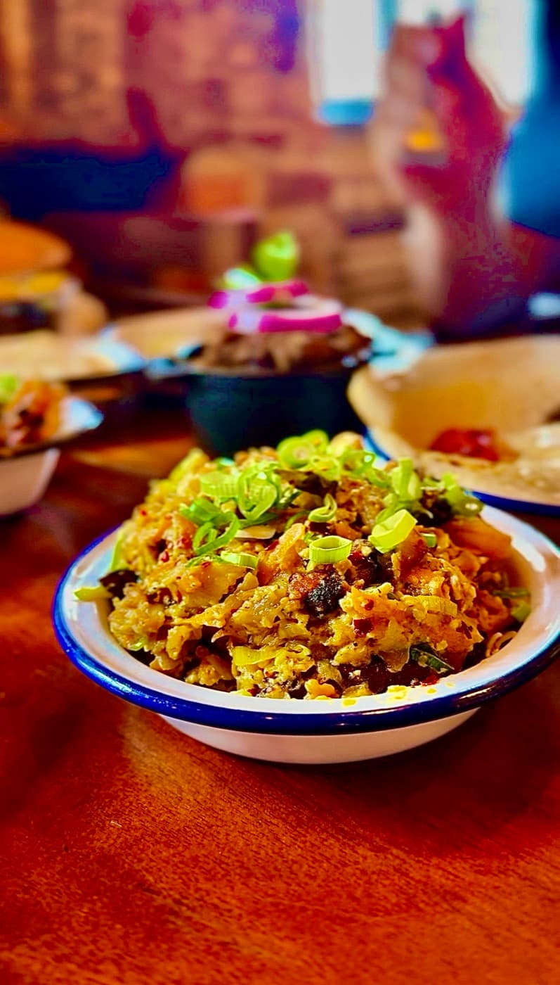 Mixed seafood kotthu at The Coconut Tree Oxford: chopped roti tossed with calamari, prawns and fish in an enamel bowl, topped with sliced spring onion