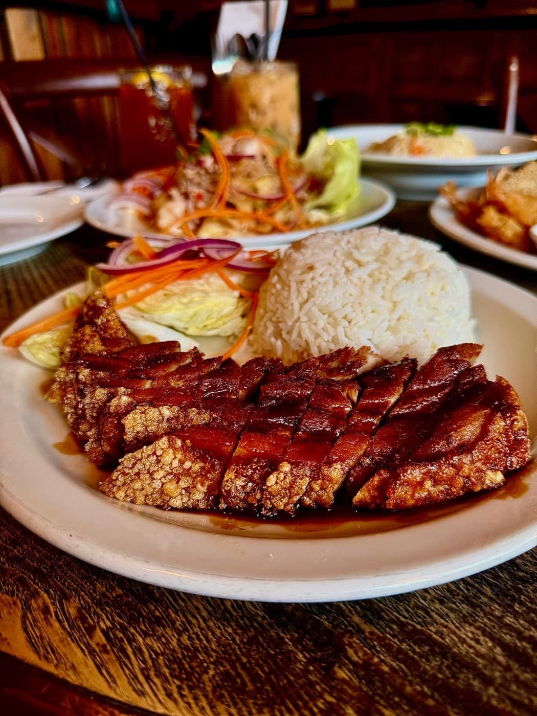 Crispy pork on rice at The Old Tom Oxford, sliced over sweet soy sauce with jasmine rice and a side salad