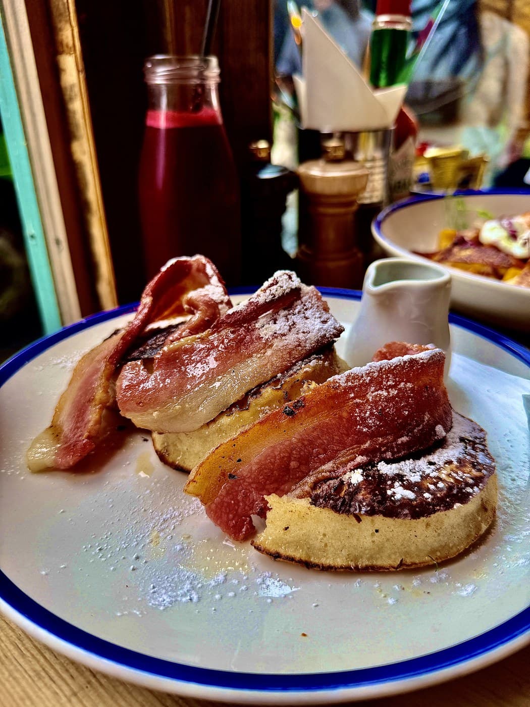 The maple glazed bacon and syrup frumpet at Oxford Brunch Bar: French toast crumpets draped with rashers of bacon, dusted with icing sugar and served with a small jug of syrup