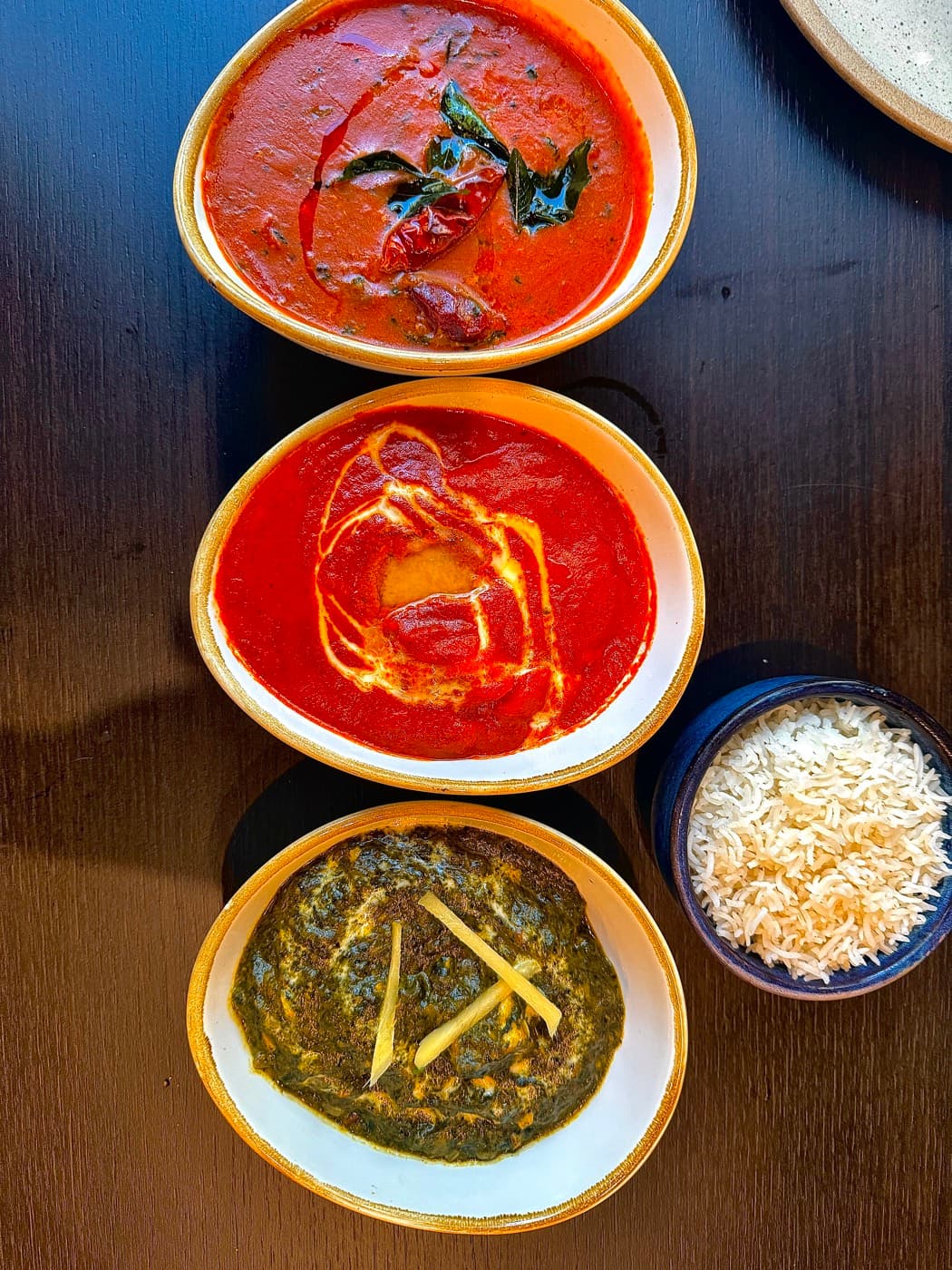 Three curries at Tempering — prawn gassi, butter chicken and palak paneer — with a bowl of basmati rice
