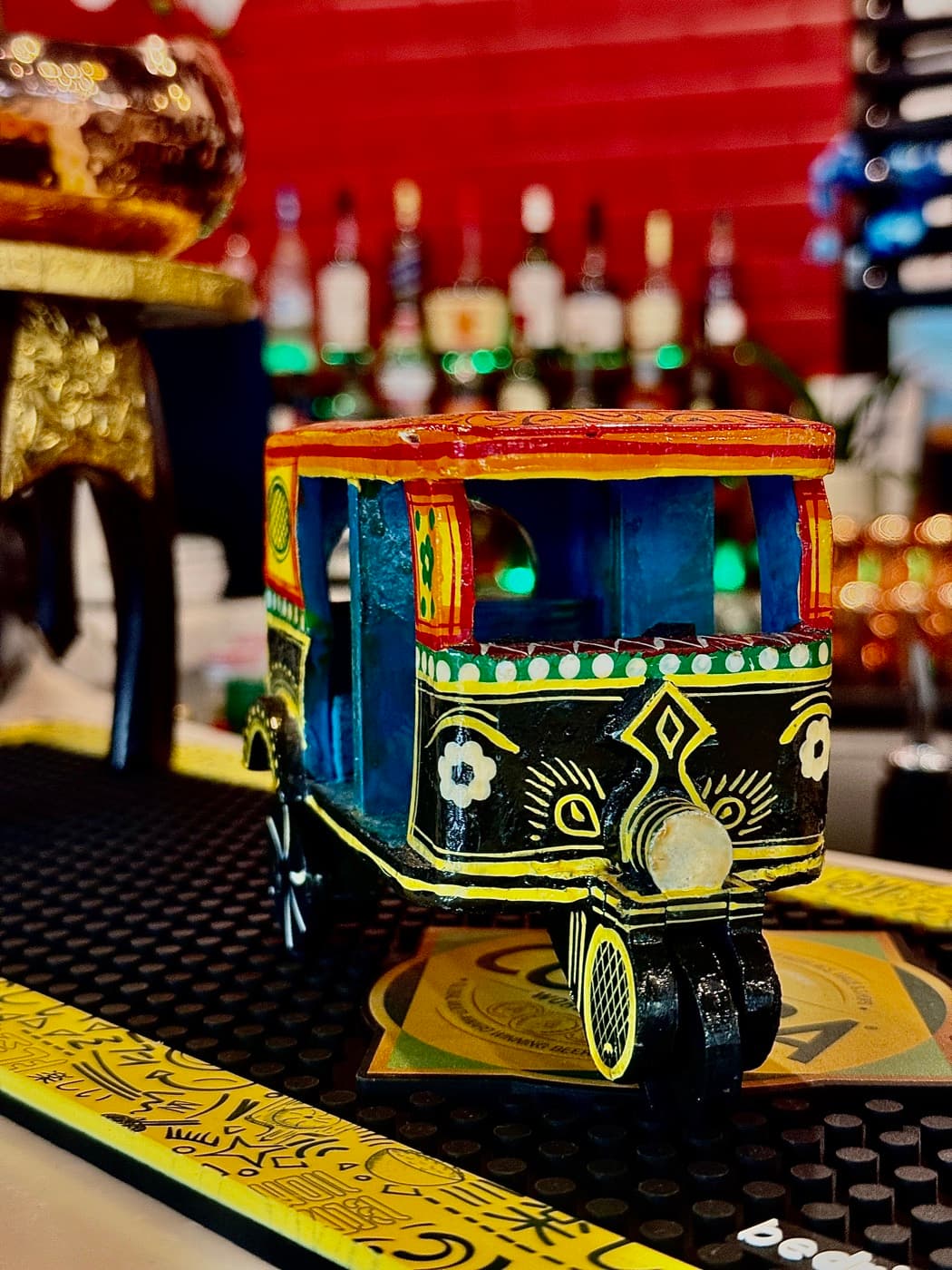 A brightly painted model tuk-tuk decorating the bar at Tempering